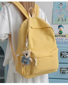 Grand sac à dos d'étudiant en toile jaune avec un porte-clé ours et le logo TUTlle