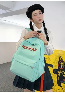 Vue détaillée d'un modèle portant un sac à dos d'étudiant bleu clair avec broderie HOKEAN
