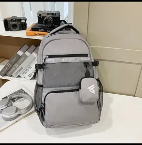 Grauer Rucksack im akademischen Stil mit Netztasche und kleinem Beutel auf dem Tisch.