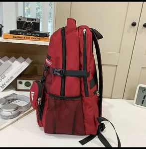 Seitenansicht eines großen roten Schulrucksacks mit Netztasche und kleinem Beutel.