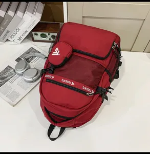 Roter Reiserucksack mit großem Fassungsvermögen und Netztaschen auf einem weißen Schreibtisch