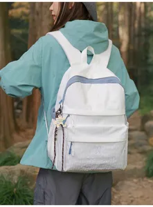 Une fille portant un grand sac à dos blanc Mars Society dans une forêt naturelle