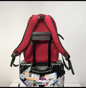 Roter Reise-Rucksack mit Kofferschlaufe, am Koffergriff befestigt