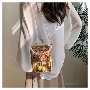 Sac bandoulière en paille tressée avec fleurs et chaîne perles sur mannequin femme