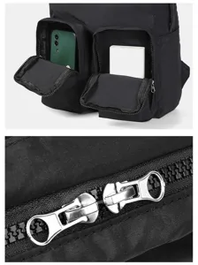 Close-up of double front pockets and metal zipper detail on black motorcycle backpack
