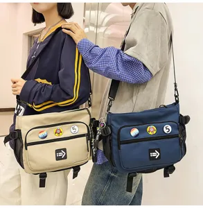 Detail of two Korean style large messenger bags in beige and navy blue worn by models