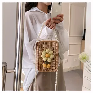 Détail de la texture en osier tissé, de la fleur en tricot et de la chaîne de perles.