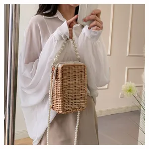 Détail d'un sac bandoulière en rotin tressé avec bandoulière en perles