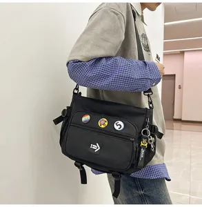 Utility style black messenger bag with decorative badges and large capacity