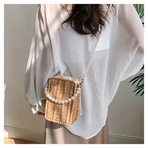 Détail d'un sac bandoulière en osier tressé avec bandoulière en perles