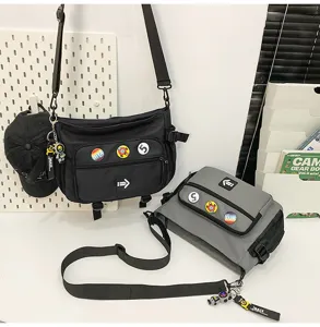 Close-up showing black and grey messenger bags with decorative badges and straps.