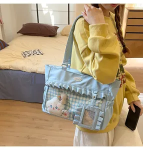 Nahaufnahme einer hellblauen Ita-Tasche mit transparentem Sichtfenster und Rüschen.