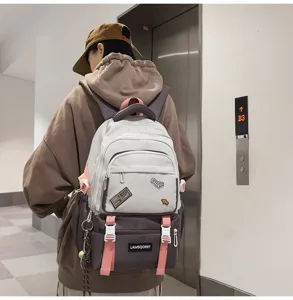 Stylish campus style color-blocked schoolbag with decorative patches worn by model