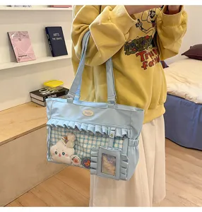 Hellblaue Ita-Tasche mit Rüschen, Klarsichtfenster und Plüschtier-Deko im Lifestyle-Look