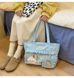 Detailansicht der hellblauen Ita-Tasche mit Rüschen und transparentem Fenster.