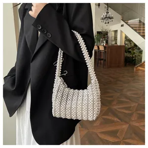 Elegante handgewebte Kunstperlen-Achseltasche, von Model in schicker Umgebung getragen