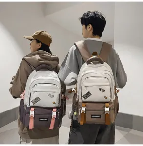 Two students wearing stylish colorblock backpacks with patches in a campus setting