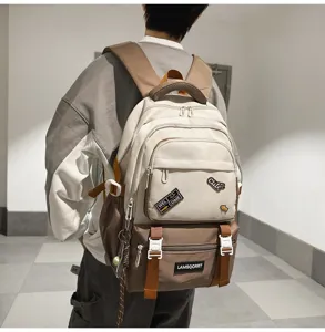 Detailed view of a stylish color-block campus backpack with patches worn by a model