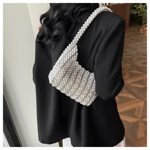 Elegante handgefertigte weiße Perlen-Unterarmtasche an einem Modell im schwarzen Blazer.