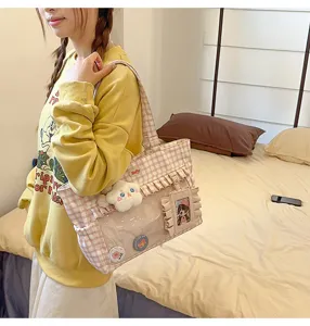 Stilvolle rosa karierte Ita-Tasche mit Rüschen und Sichtfenster, getragen von einem Model