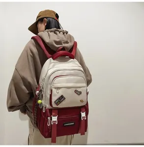 Back view of a stylish color-block school backpack with decorative patches worn by a model