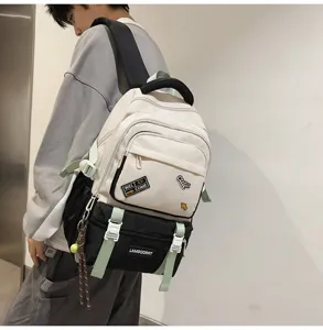 Detail of cream and black contrast student backpack with decorative patches on model