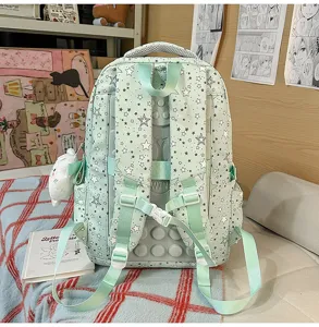 Detailed view of the cute light green star print student backpack with multi compartments.