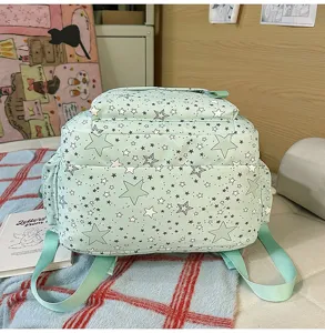 Mint green star print student school backpack detail, multi pocket design for daily use.