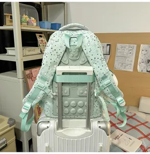Detailed close-up view of the mint green star print school backpack with convenient luggage strap.
