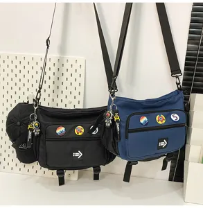Pair of black and blue workwear style messenger bags with cute astronaut patches