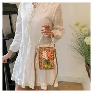 Sac bandoulière en rotin tressé main avec décor floral et poignée en perles élégante.