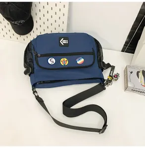 Blue Korean style messenger bag with adjustable strap and decorative badges for students