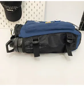 Close-up detail of blue and black utility messenger bag showing mesh side water bottle pocket.