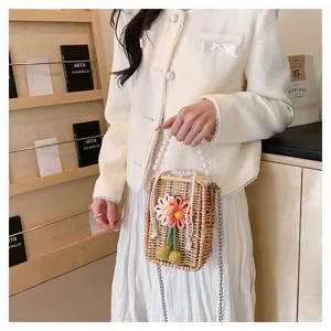 Détail d'un sac en rotin tissé main avec fleurs et poignée en perles