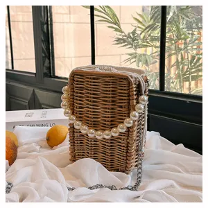 Vue détaillée d'un sac bandoulière en paille avec une poignée élégante en perles
