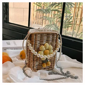 Vue détaillée du sac carré en paille tressée avec chaîne en perles et fleur au crochet jaune