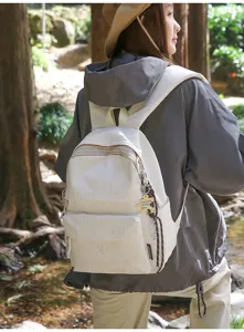 Mannequin portant un grand sac à dos blanc dans un environnement forestier naturel