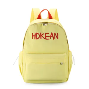 Vue frontale d'un sac à dos étudiant jaune léger avec broderie rouge