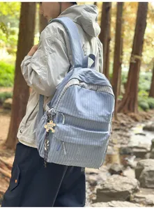 Sac à dos à carreaux bleus de grande capacité porté par un étudiant en plein air