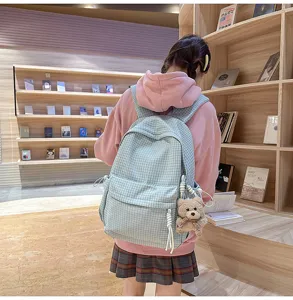 Vue de dos d'une fille portant un sac à dos à carreaux bleu clair en librairie