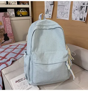 Vue détaillée d'un sac à dos à carreaux bleu clair avec des tirettes de fermeture tressées