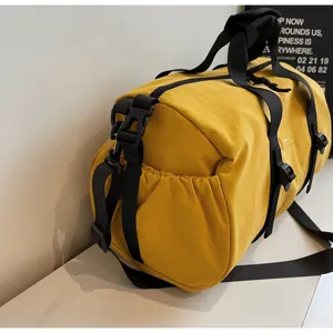 Detailopname van de duurzame nylon stof en de zwarte gesp van deze gele fitnesstas