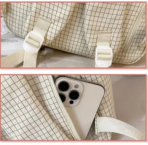 Détail des bretelles et de la poche latérale zippée d'un sac à dos d'étudiant à carreaux