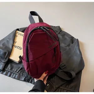 Detaillierte Nahaufnahme einer burgunderroten Streetstyle-Slingbag auf Leder.