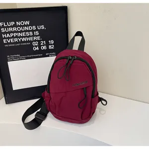 Nahaufnahme einer burgunderroten Brusttasche im Streetstyle mit verstellbarem Riemen