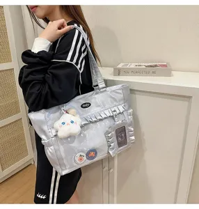 Detailansicht einer silbernen Ita-Bag mit Rüschen, Klarsichtfenster und Sternanhänger.