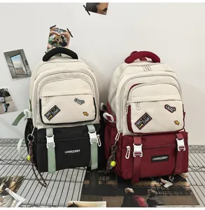 Detail view of two color-block school backpacks in black and burgundy with patches