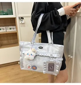 Silberne schillernde Ita-Tasche mit transparentem Sichtfenster und süßen Anhängern