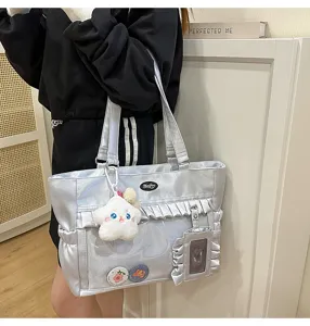 Detailansicht der silbernen schimmernden Ita-Tasche mit Klarsichtfenster und Rüschen