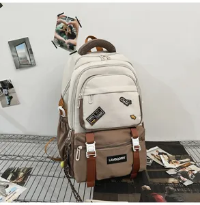 Close-up of color-blocking campus backpack with 'LAMSQORRT' and 'cute' patches.